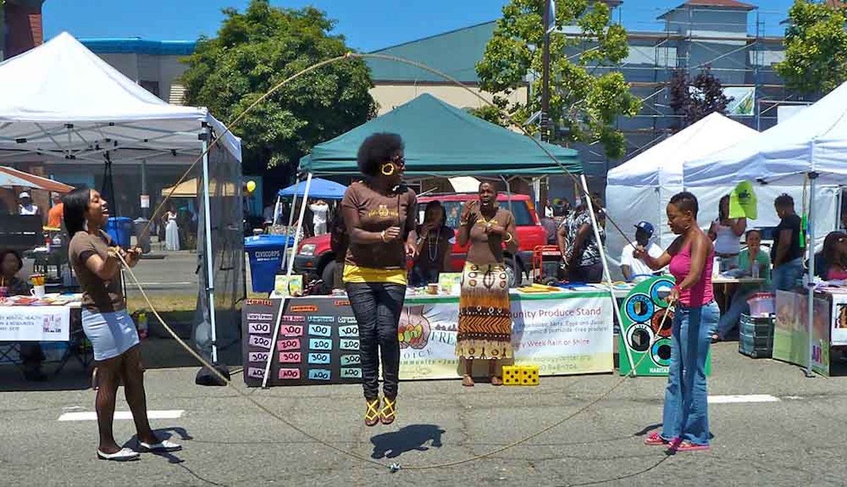 A woman is doing a hula hoop in front of a crowd of people.