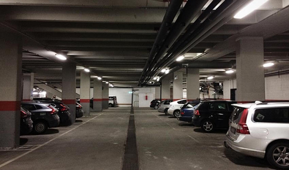 A parking garage with a lot of cars parked in it.