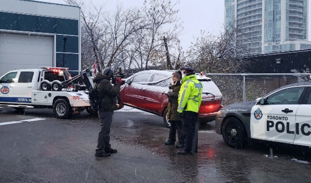 Toronto police tow a car in the snow.