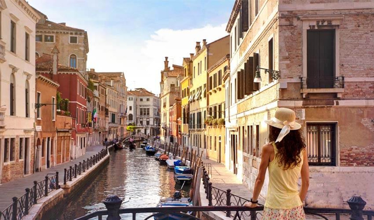 A woman looking out over a canal in venice.