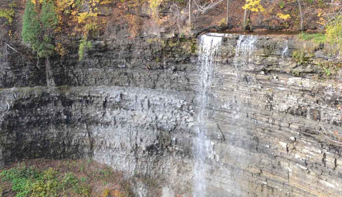 An aerial view of a waterfall on a cliff.