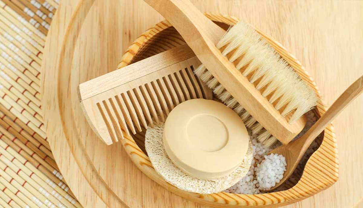 A wooden bowl with a brush, soap, and salt.