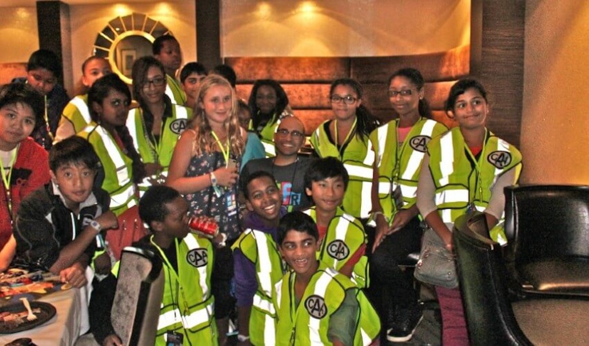 A group of children in safety vests posing for a photo.