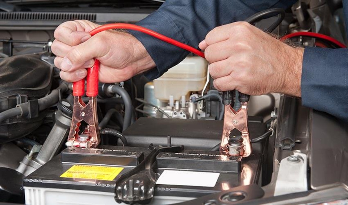 A man is working on a car battery.