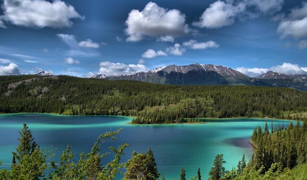 A blue lake surrounded by mountains and trees.