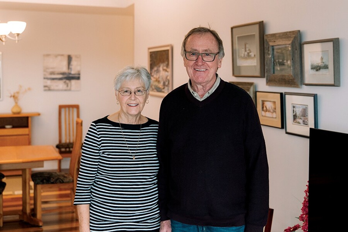 An older couple standing in a living room.