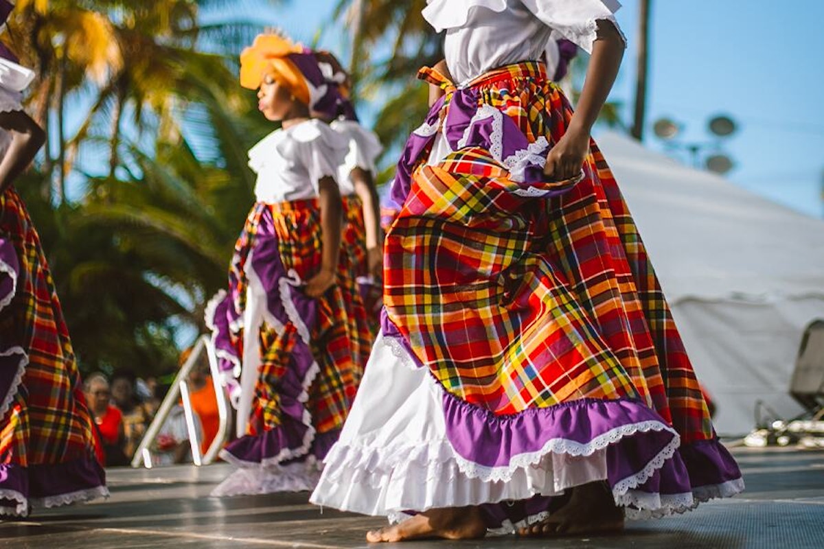 Traditional dancers in colorful skirts performing at an outdoor event.