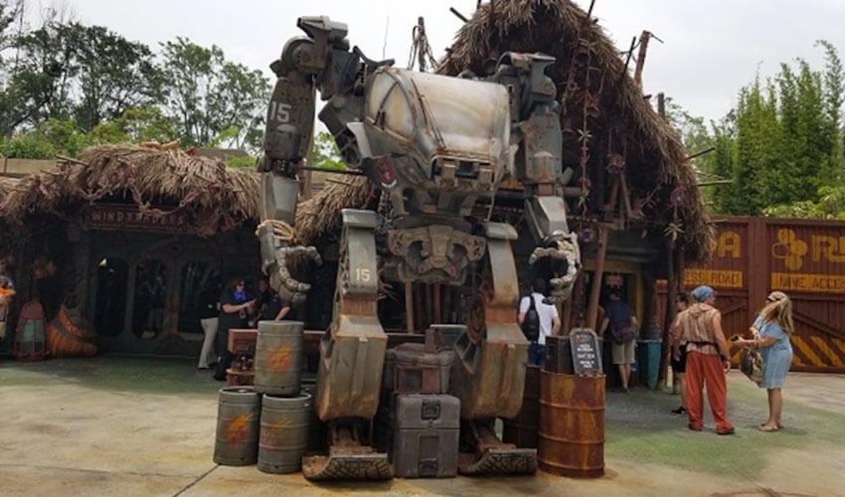 A large robot is standing in front of a building.