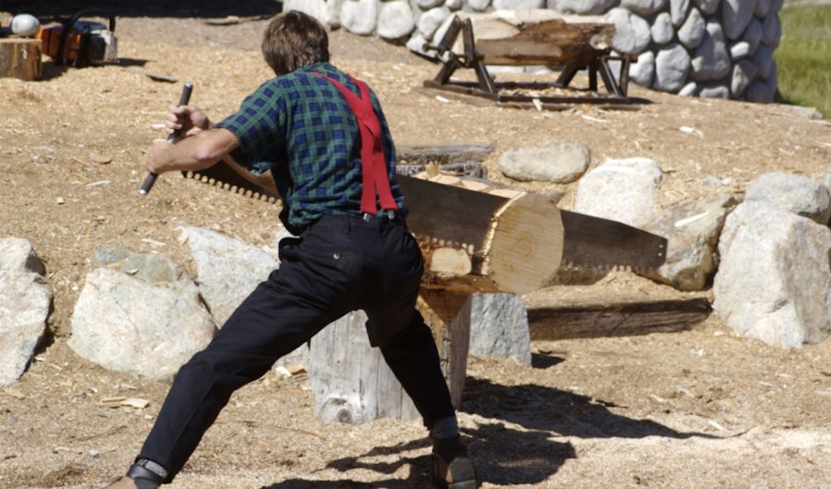A man cutting wood with a chainsaw.