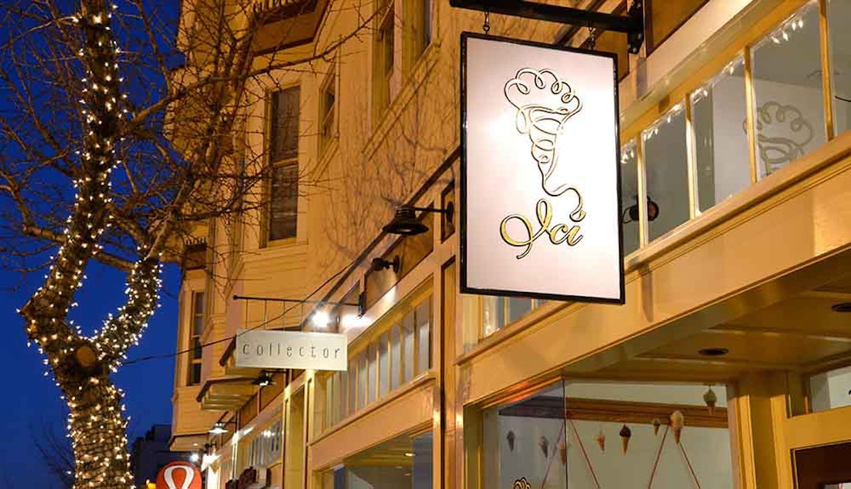 A sign for a restaurant on a street at night.