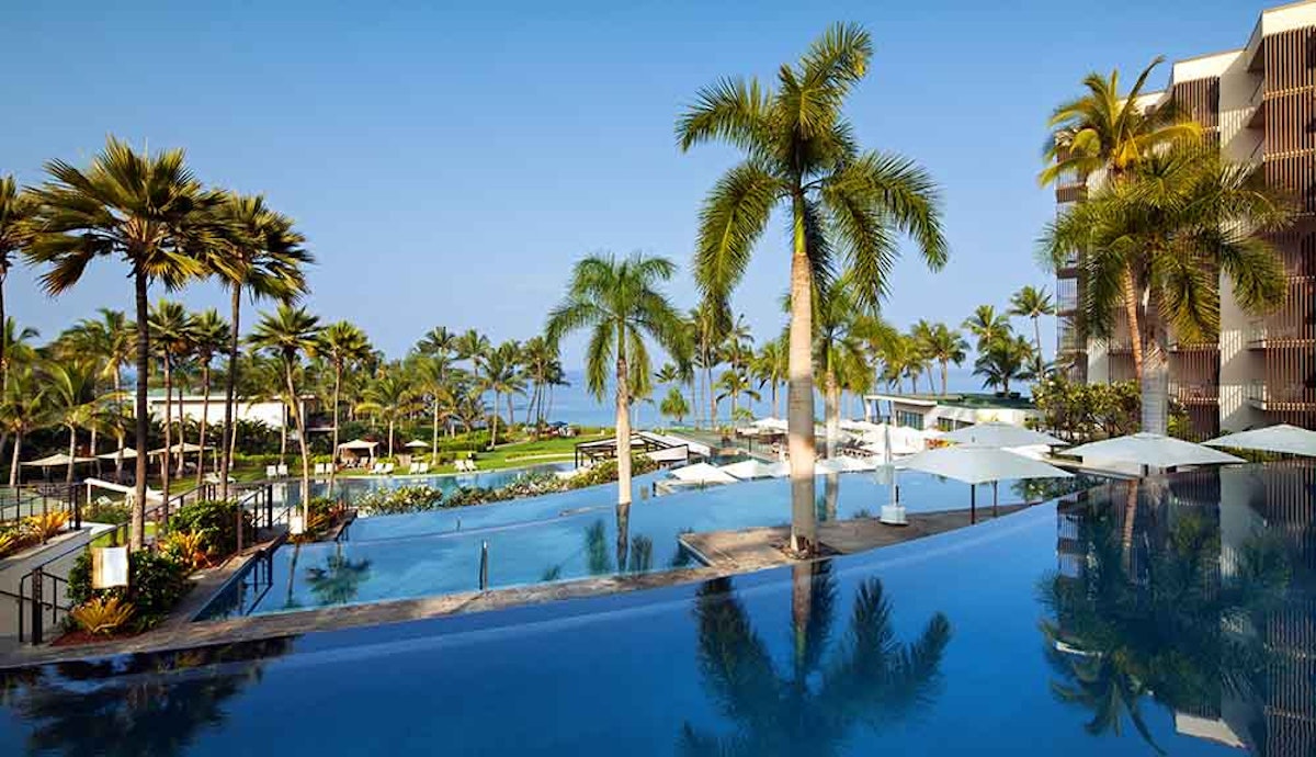 A swimming pool surrounded by palm trees and palm trees.