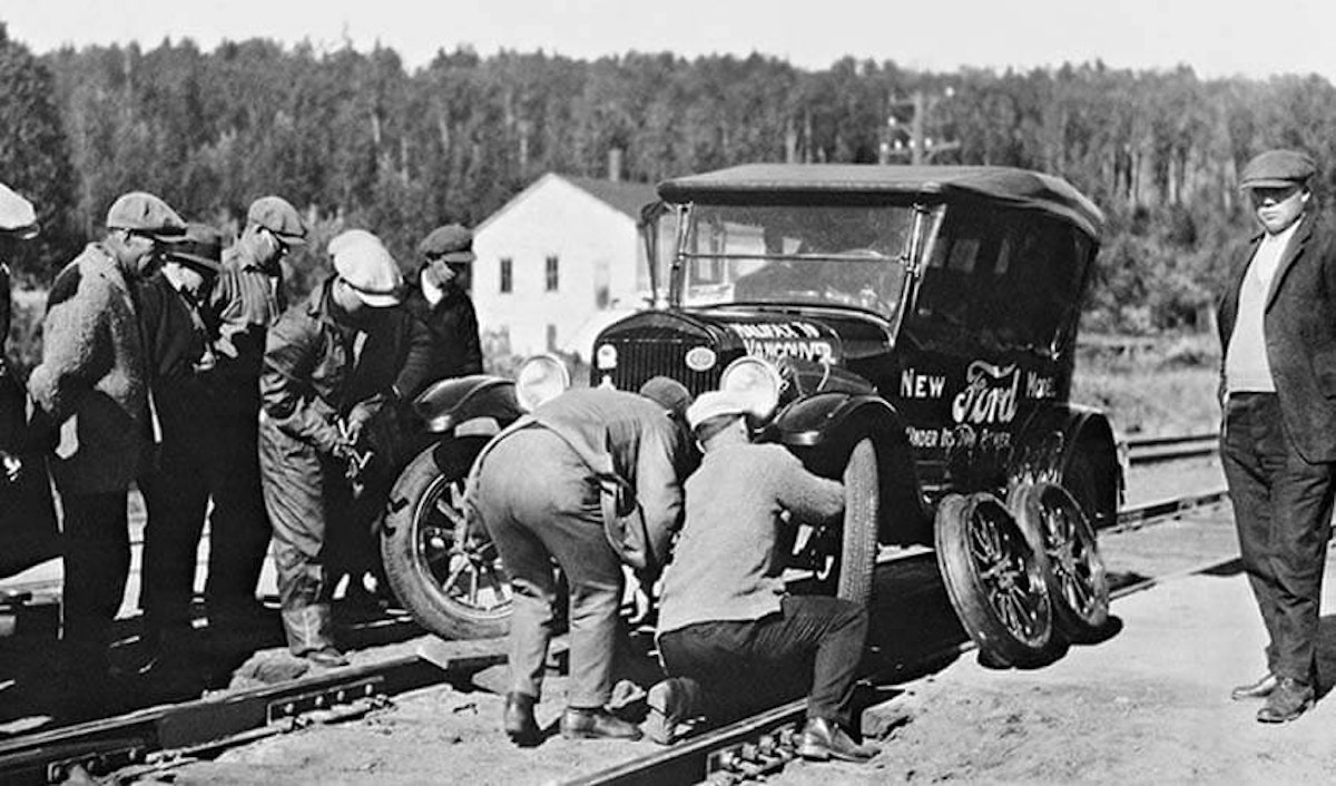 A group of men working on a car on a train track.