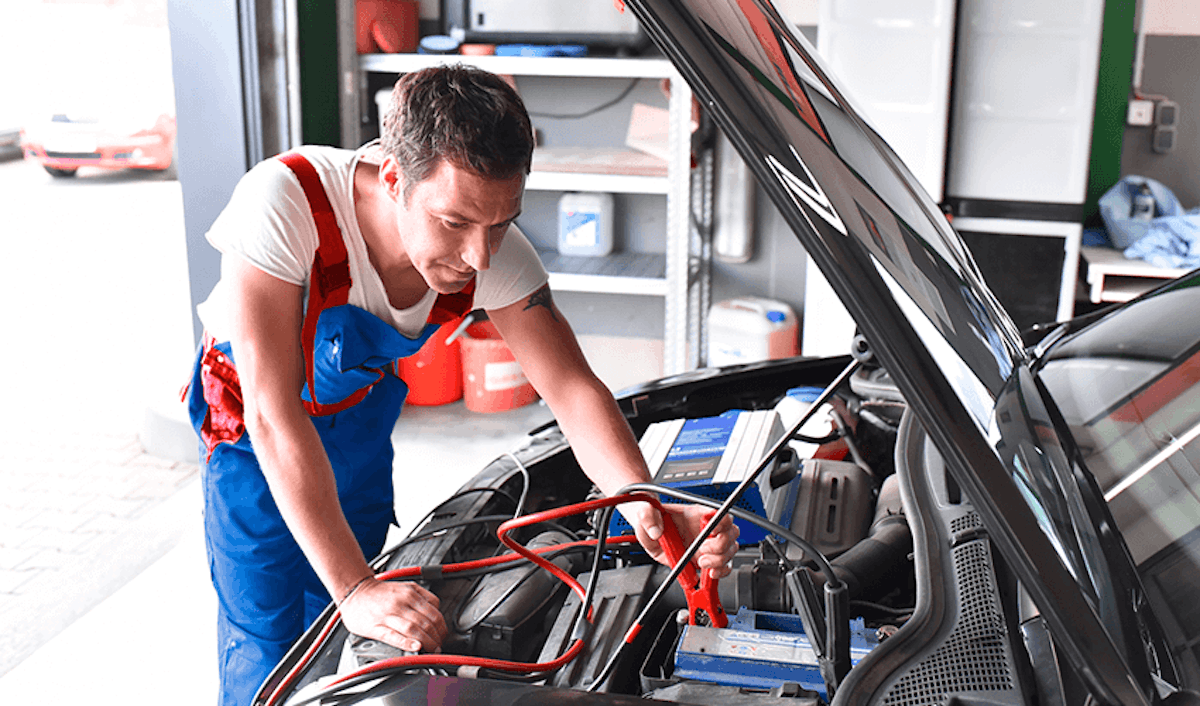 A mechanic working on a car's battery.
