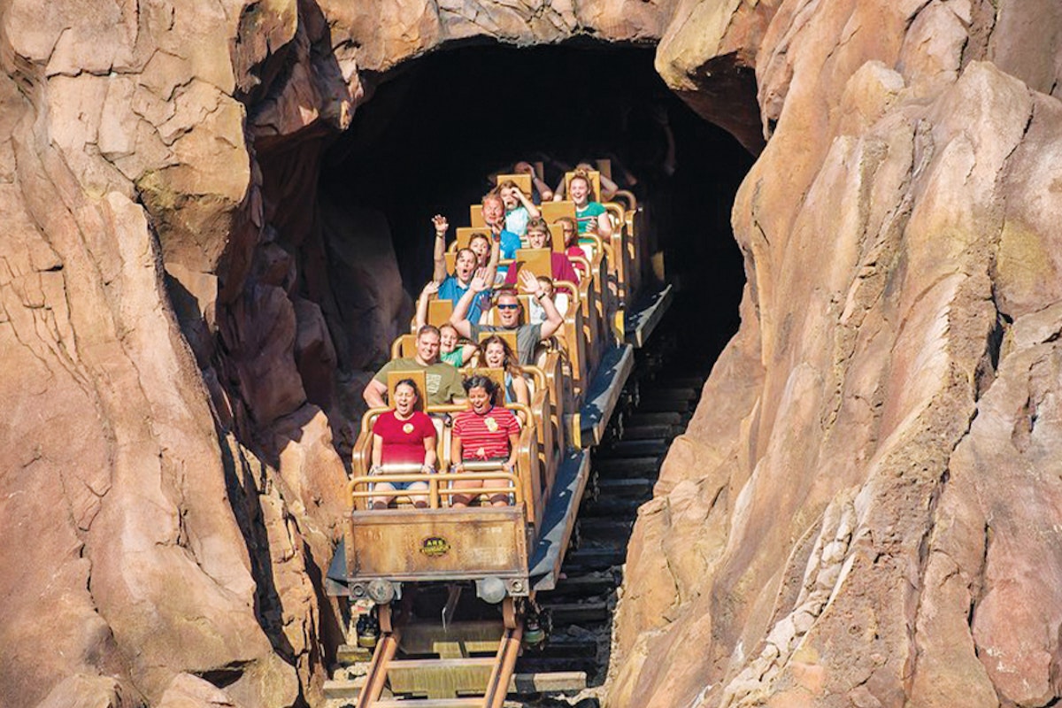 A group of people riding a train through a cave.