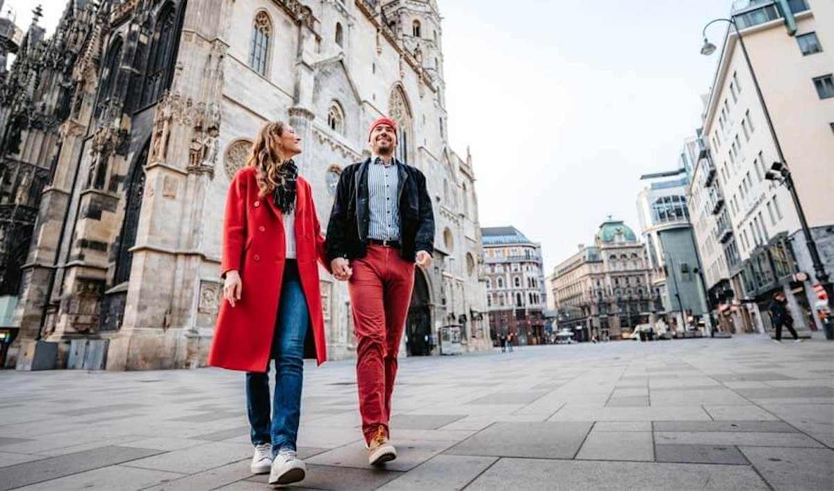 A couple walking in front of a cathedral in vienna.