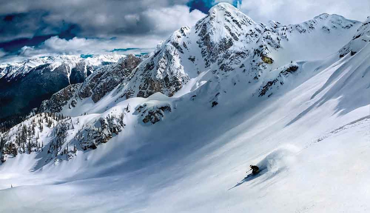 A skier is skiing down a snow covered mountain.