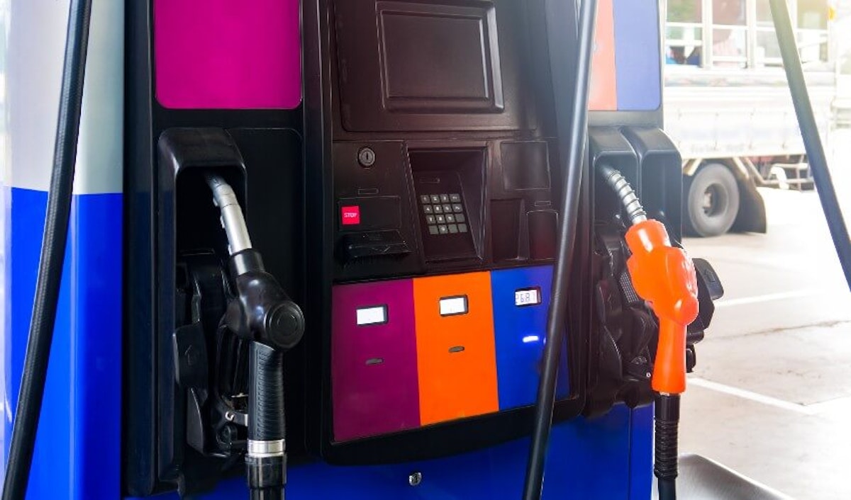 A blue and orange gas pump at a gas station.