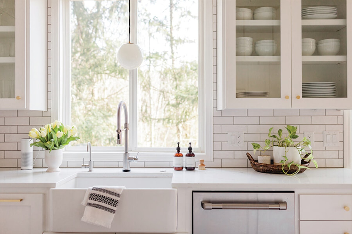 A kitchen with white cabinets and white countertops.