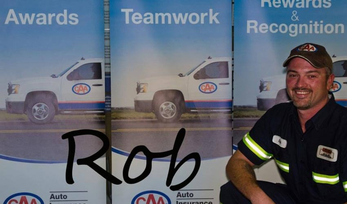 A man standing in front of a banner with the word rob.