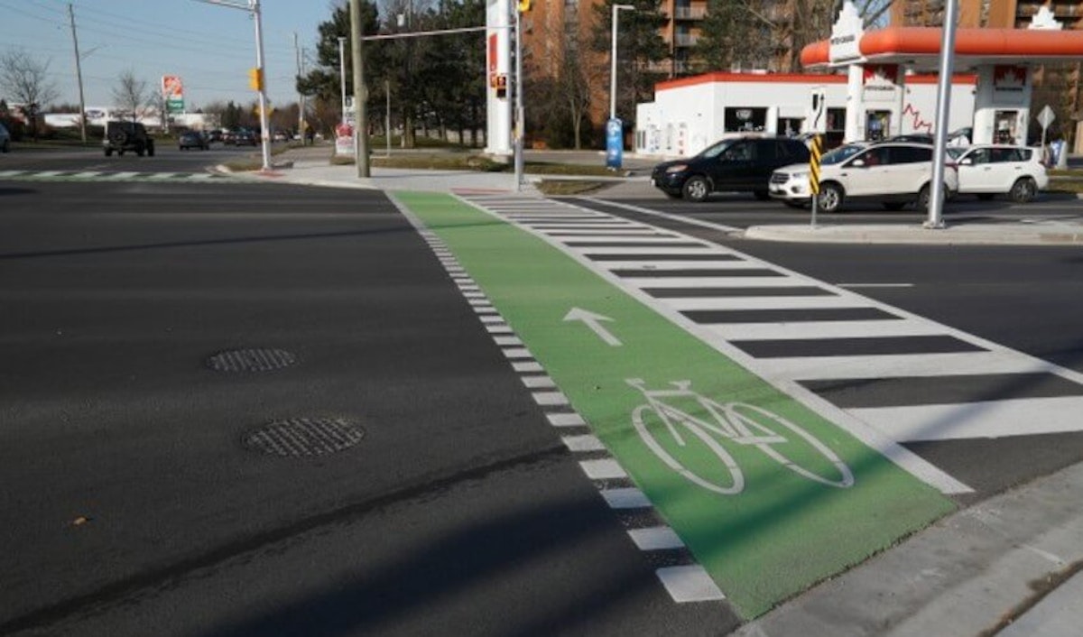 A green bike lane is painted on a street.
