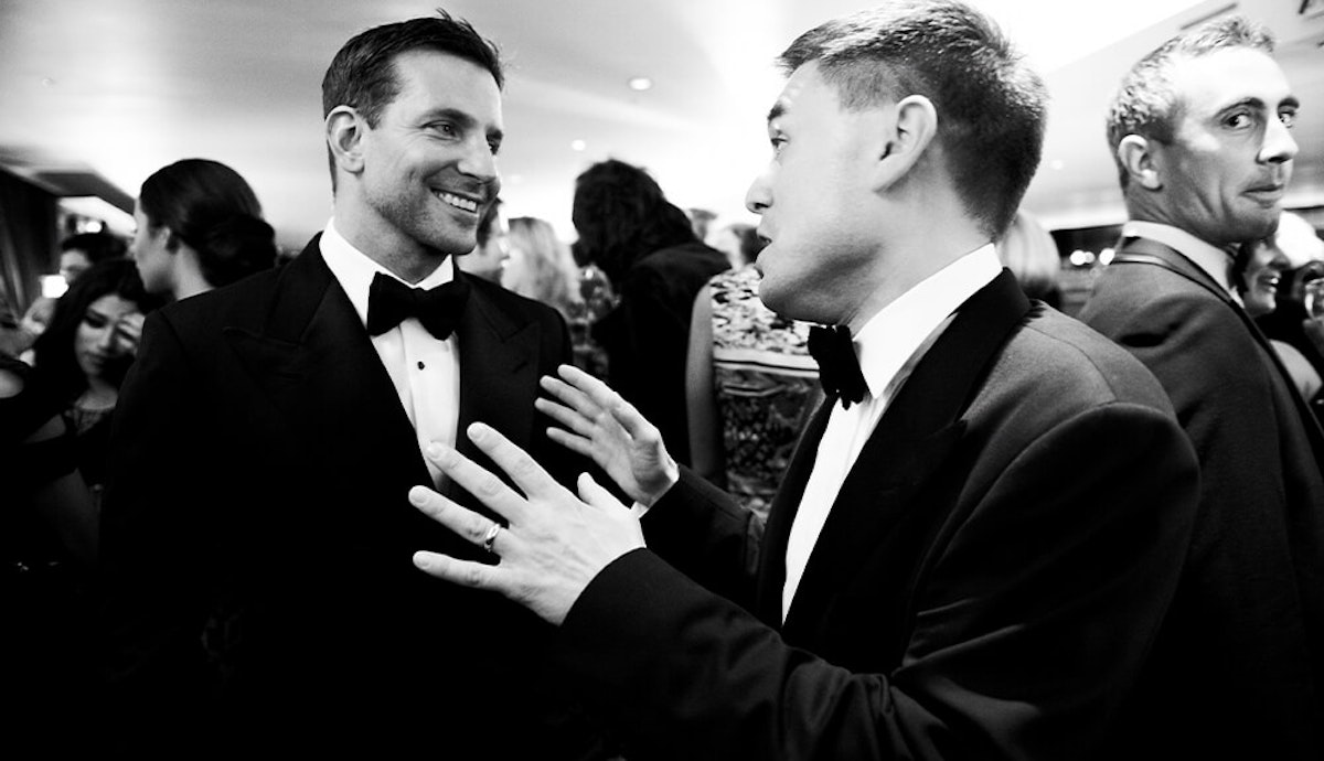 Two men in tuxedos talking to each other.
