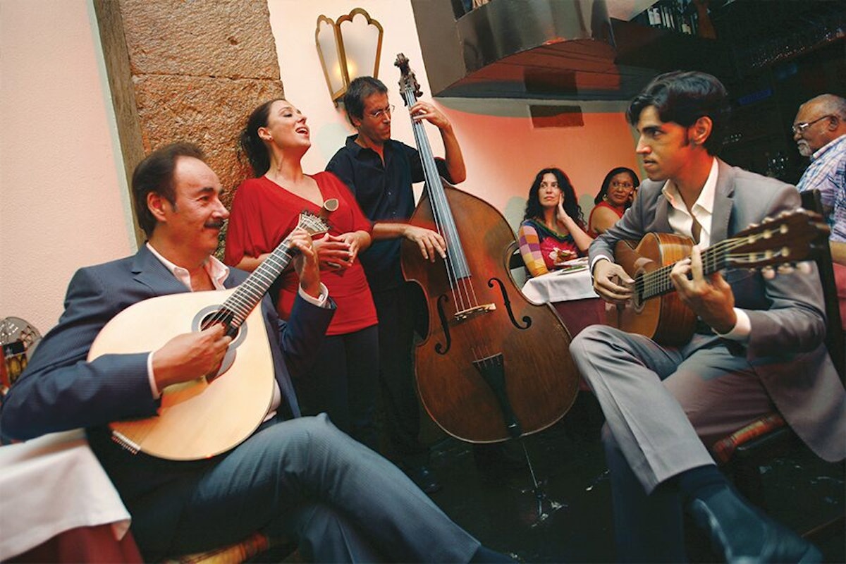 A group of people playing guitars in a restaurant.