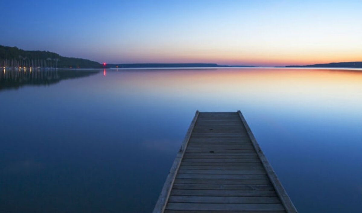 A dock on a lake at sunset.