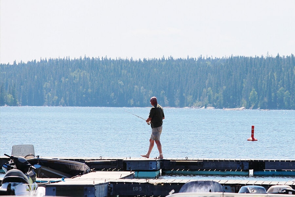 A man fishing on a dock.