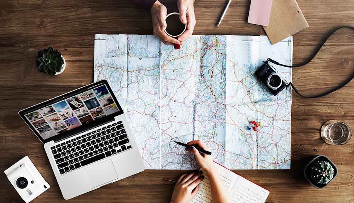 A group of people sitting at a table with a map and a laptop.