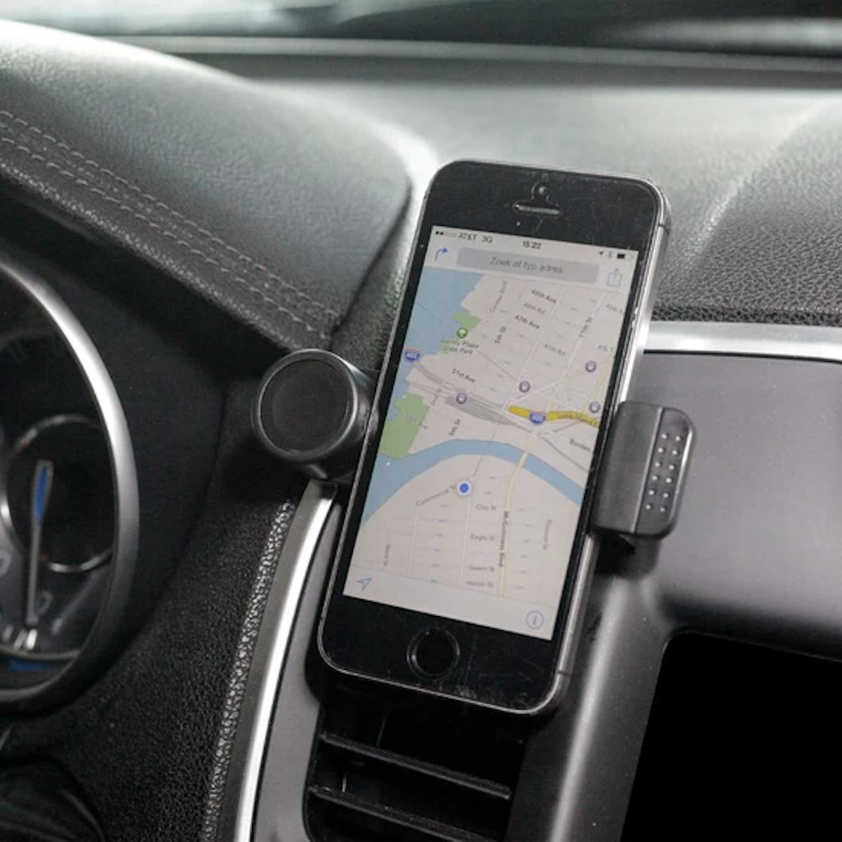 A cell phone on a holder in a car.