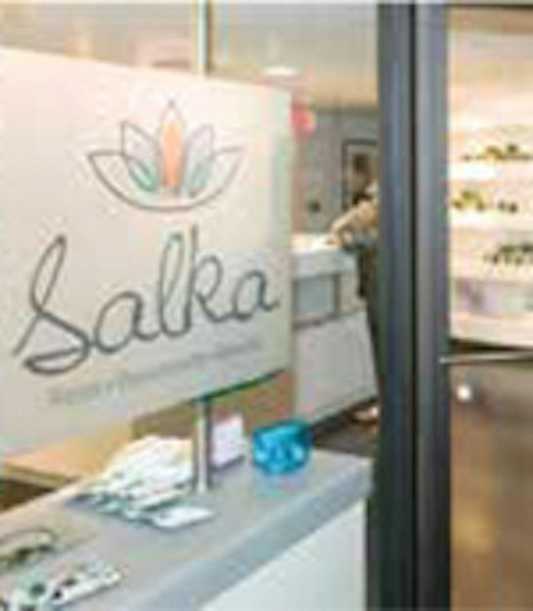 Glass door leading to a boutique with the name "salka" on the wall behind the checkout counter.