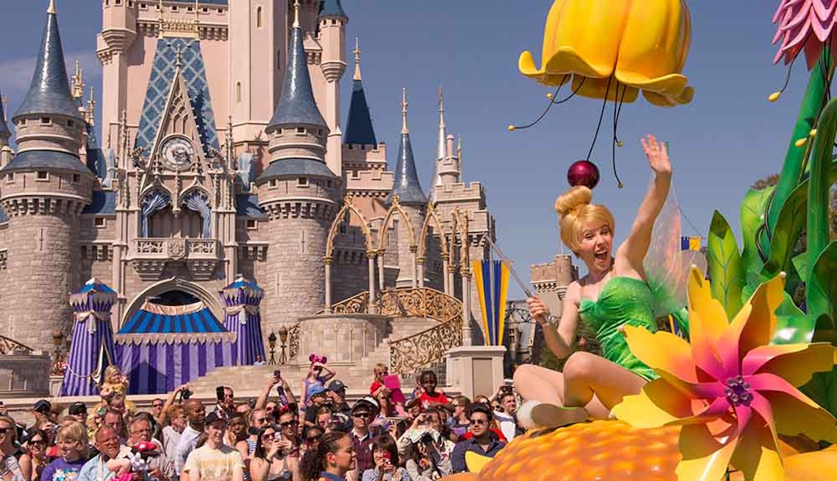 A tinker bell float in front of a castle.