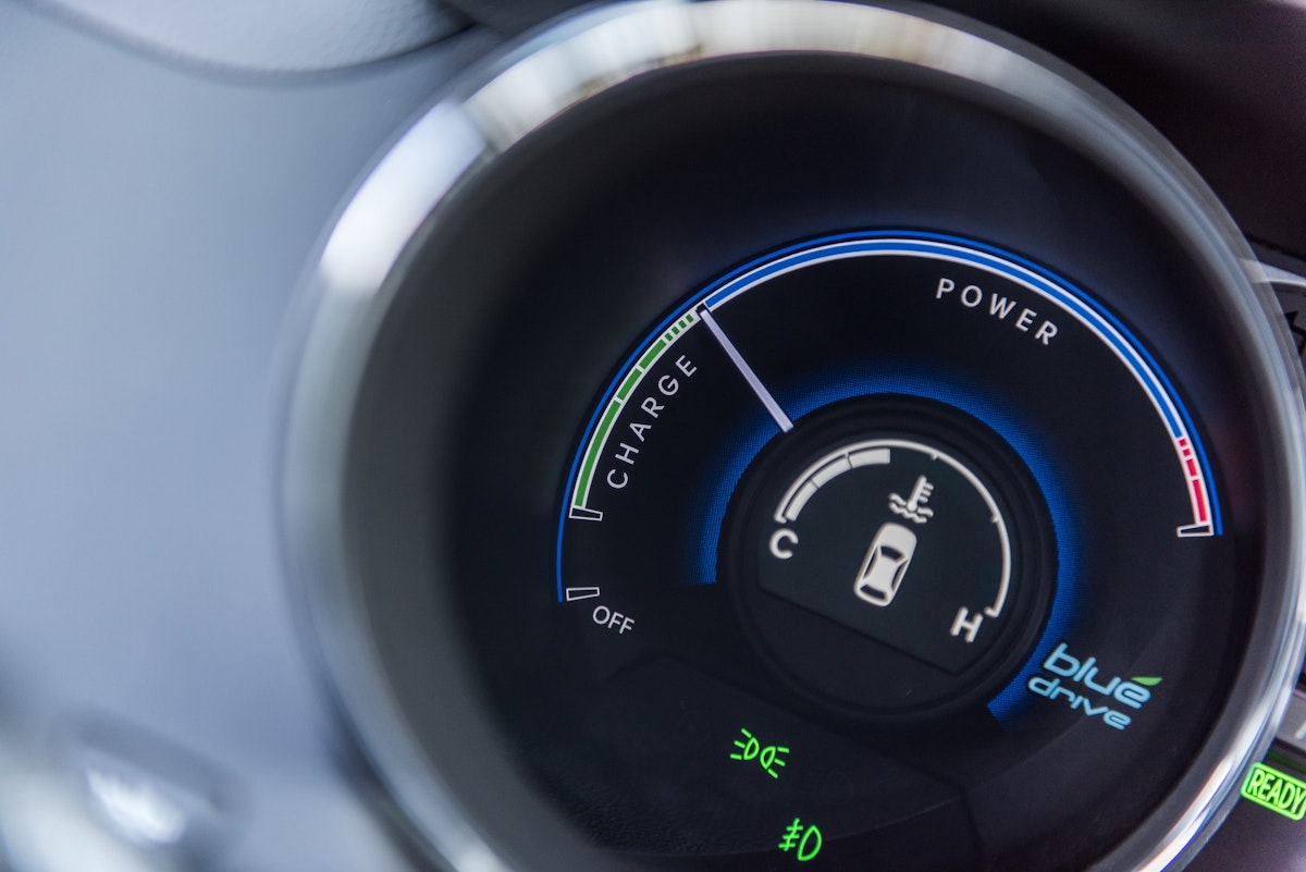 Close-up of a hybrid vehicle's power gauge indicating battery charge and power usage.