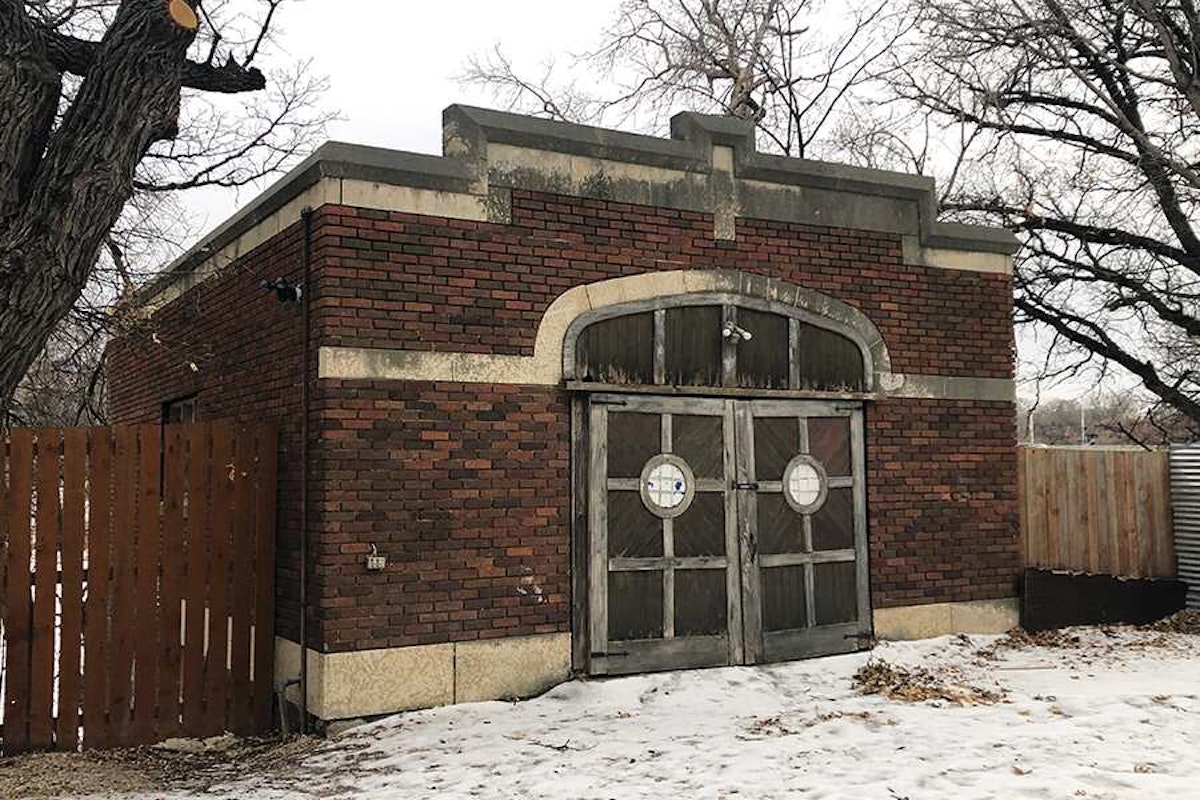 A brick building with a door in the snow.