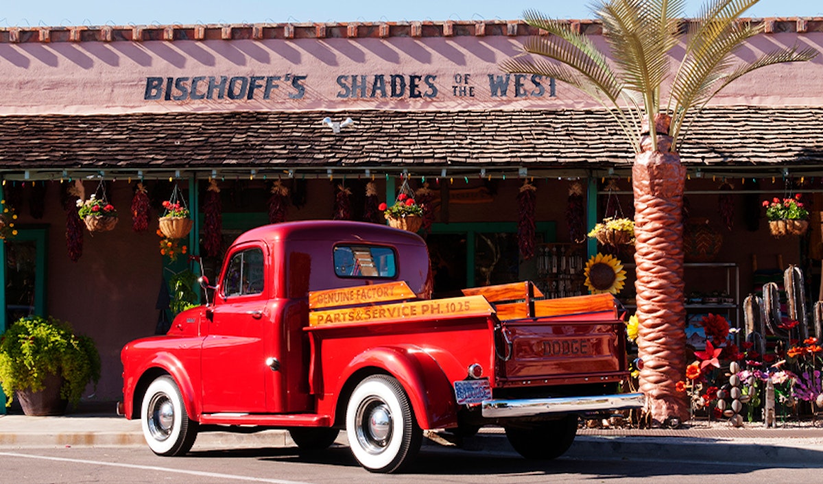 A red truck parked in front of a store.