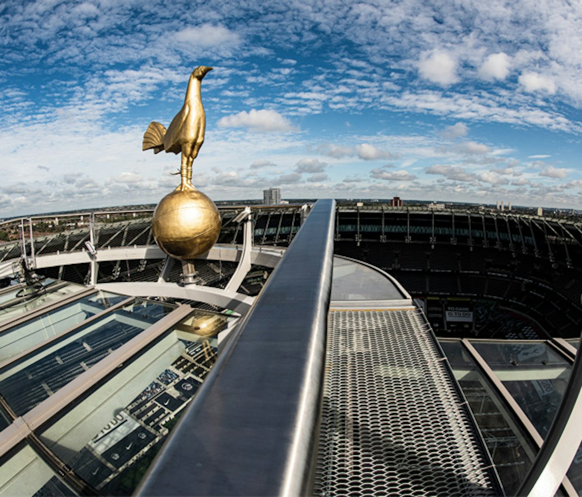 Golden bird statue on a globe overlooking a stadium from an elevated perspective.
