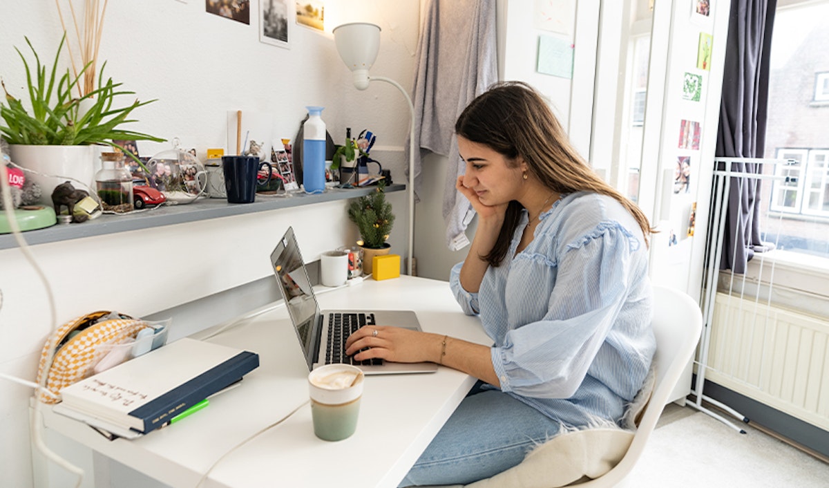 A young woman working on her laptop in her home office.