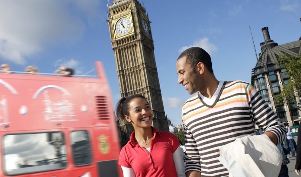 A couple walking in front of big ben in london.