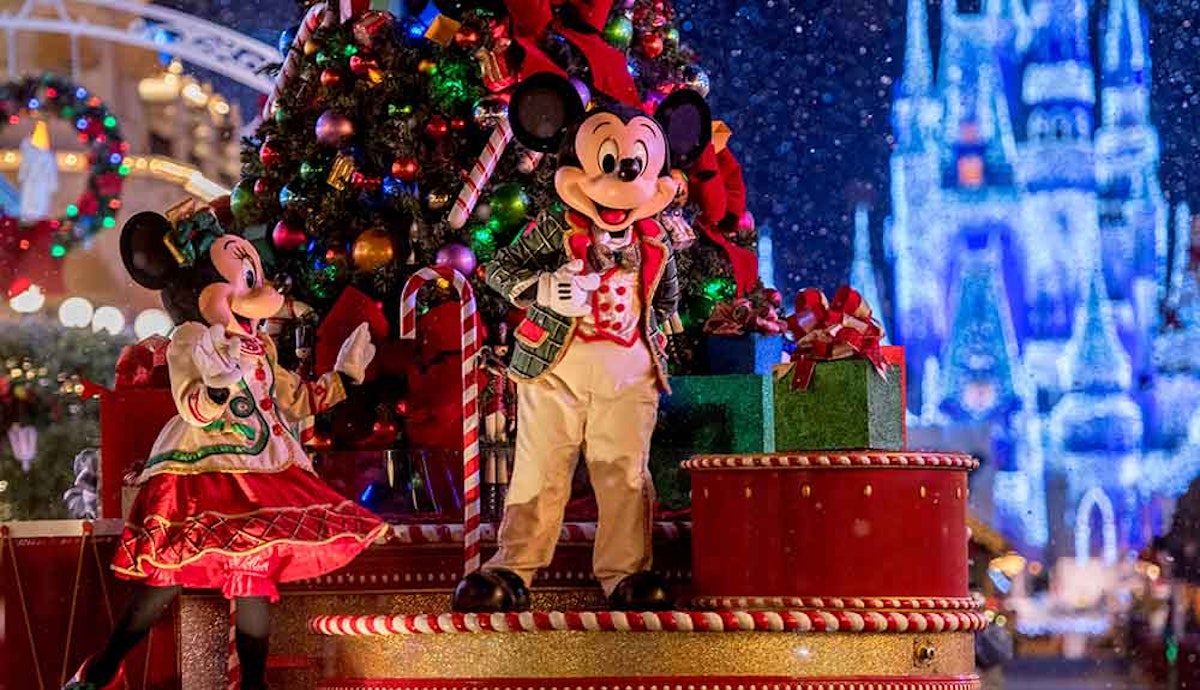 A mickey mouse float with a christmas tree in the background.