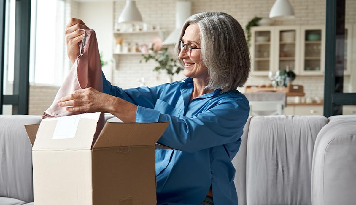 A woman is opening a box in her living room.