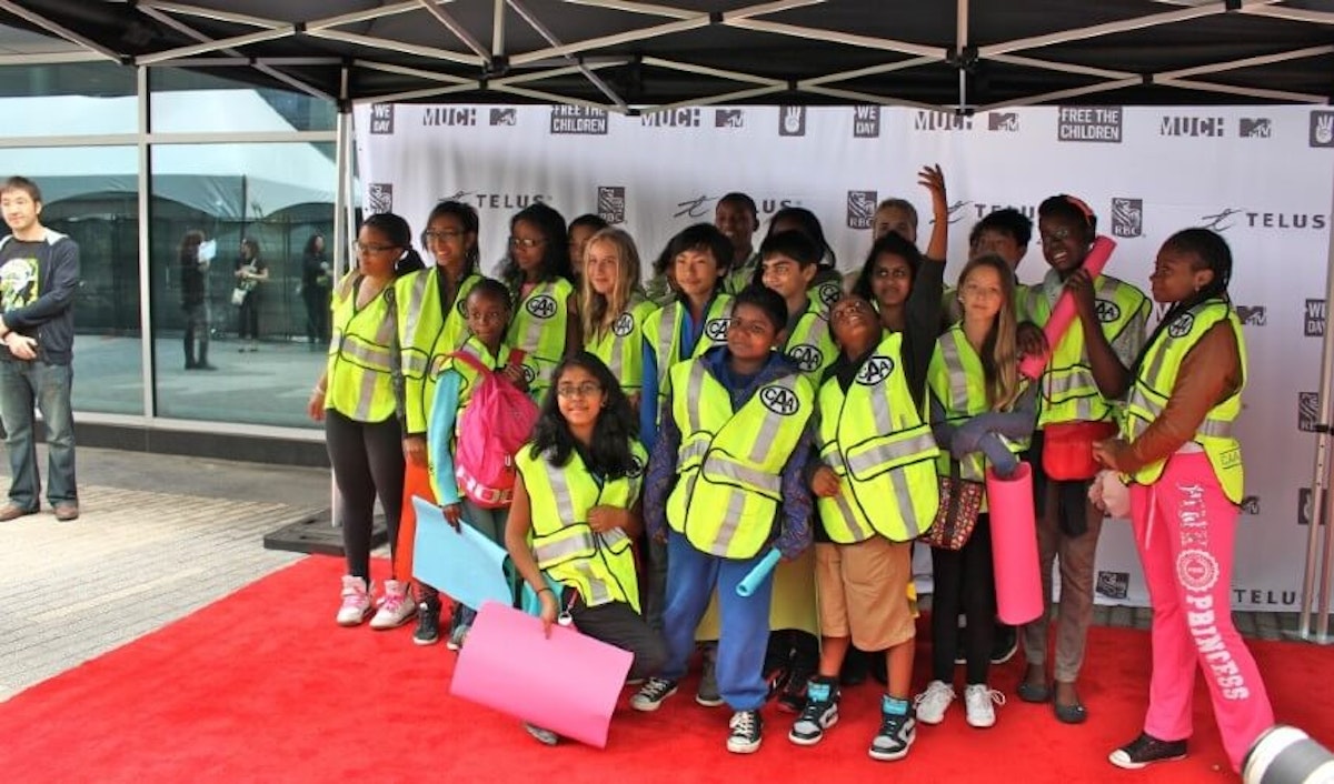 A group of children wearing reflective vests.