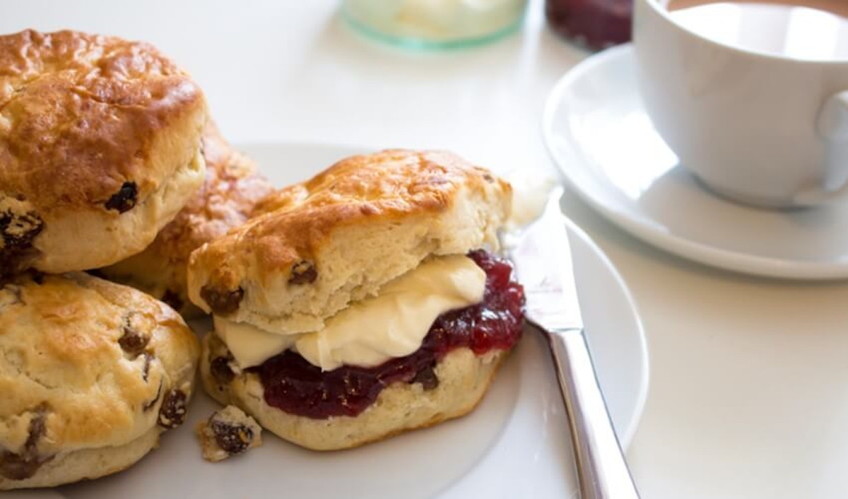 Scones with jam and cream on a plate.