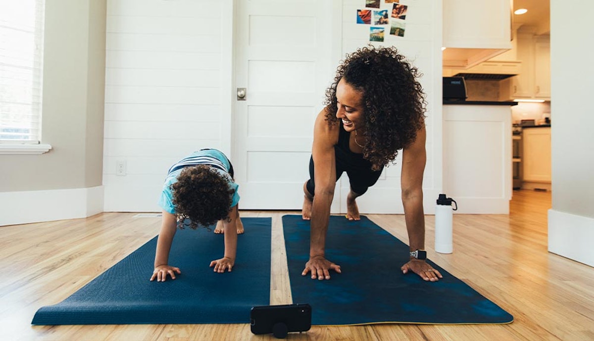 A woman and a child doing yoga in a living room.