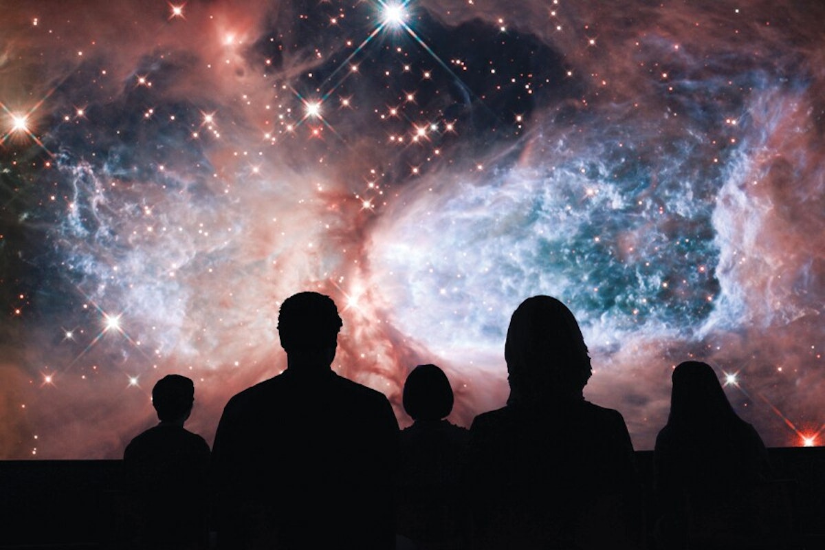 A group of people standing in front of a nebula.