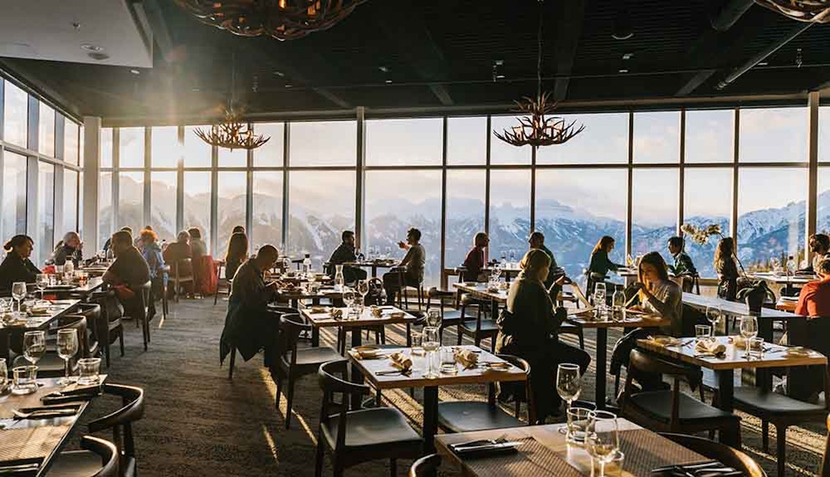 A restaurant with large windows overlooking the mountains.