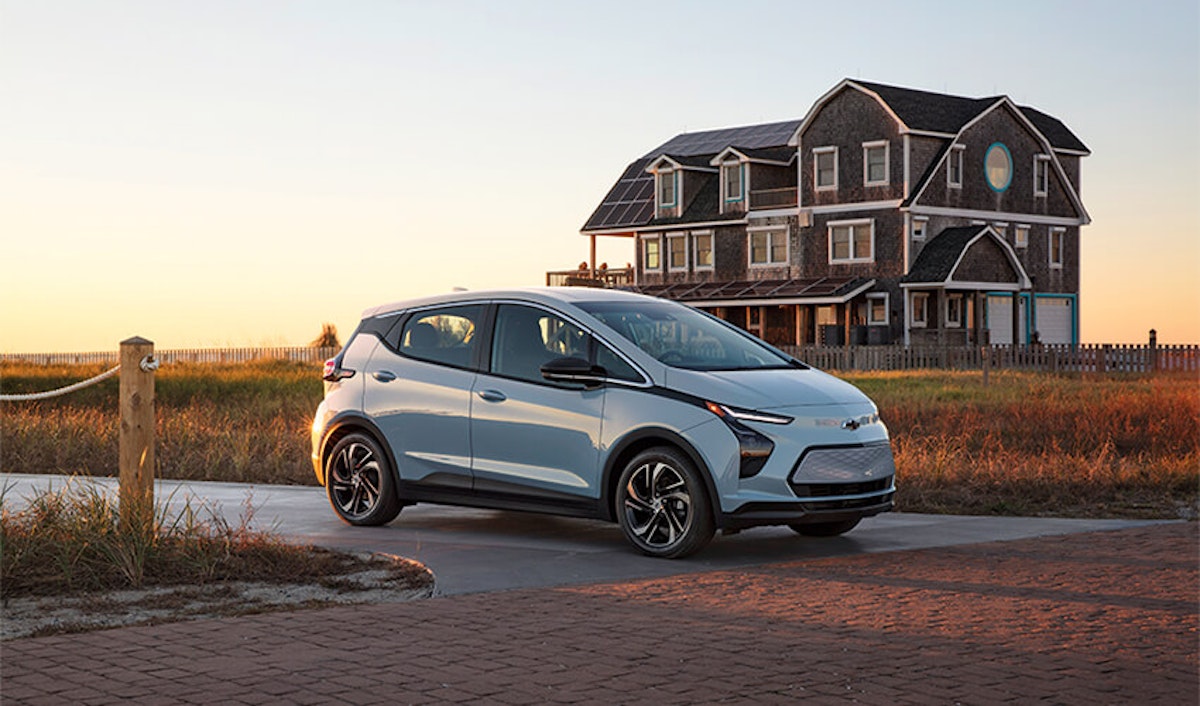 The 2020 chevrolet bolt is parked in front of a house.