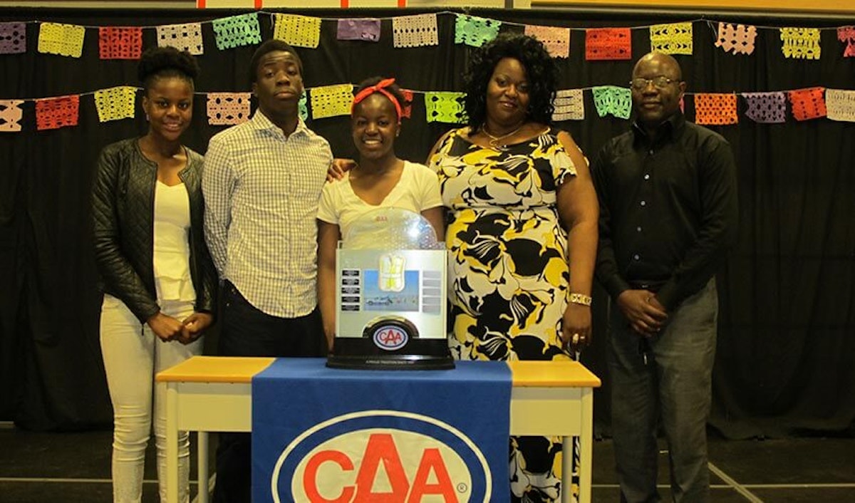 A group of people posing in front of a caa machine.