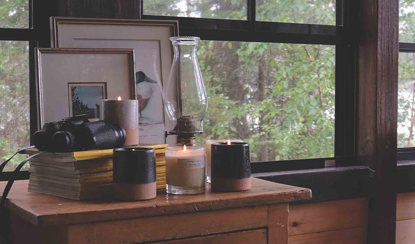 Candles on a table next to a window.