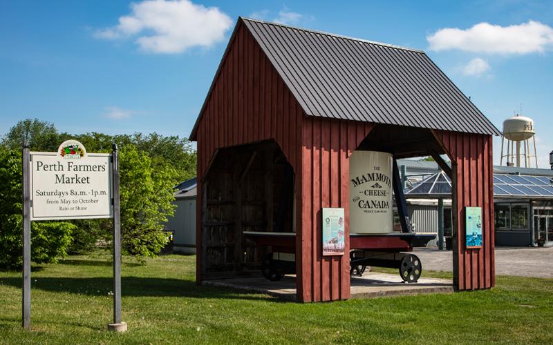 Small red barn in Perth, Ontario with a sign that says Perth Farmer’s Market.