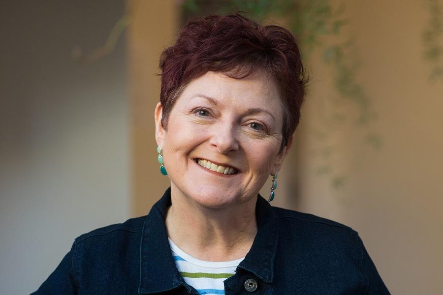 A woman with red hair smiling for the camera.
